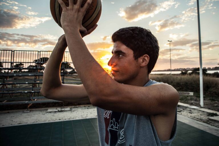 boy plays-basketball-at-sunset